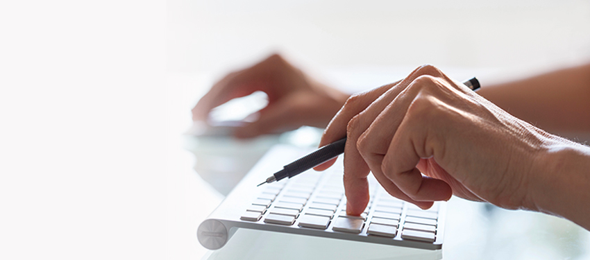 Hands typing on a computer keyboard